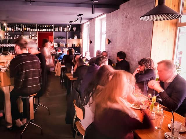 Gäste am Abend an der Theke und an den Tischen