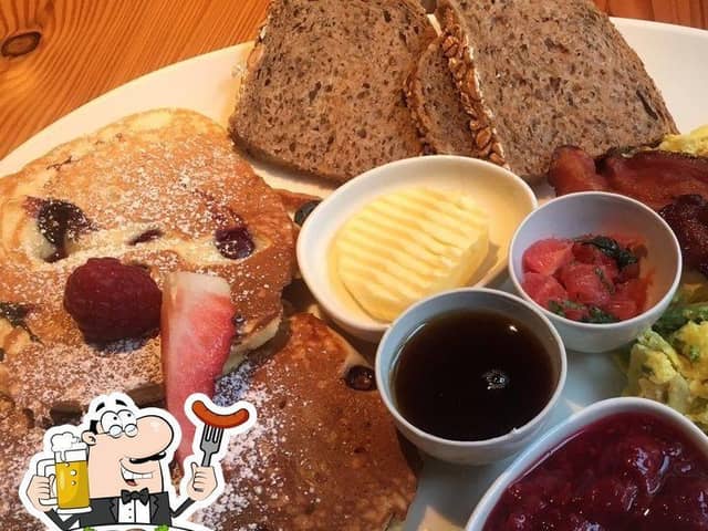 Großer Frühstücksteller mit Rührei, Bacon, Brot, Butter und Marmelade