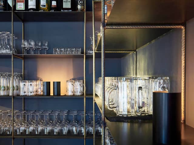 Regal hinter der Bar mit gestapelten Gläsern und Flaschen